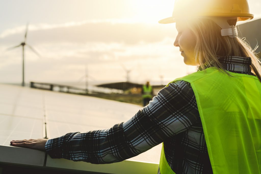 Young female engineer in front of wind turbine installation